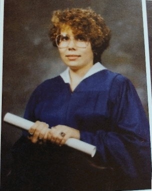 Senior high school yearbook picture of Faith in a blue robe holding a diploma (1990)